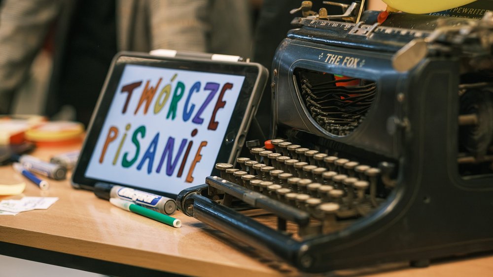 tablet z napisem twórcze pisanie obok maszyny do pisania