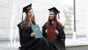 Absolwentki trzymające prace magisterskie